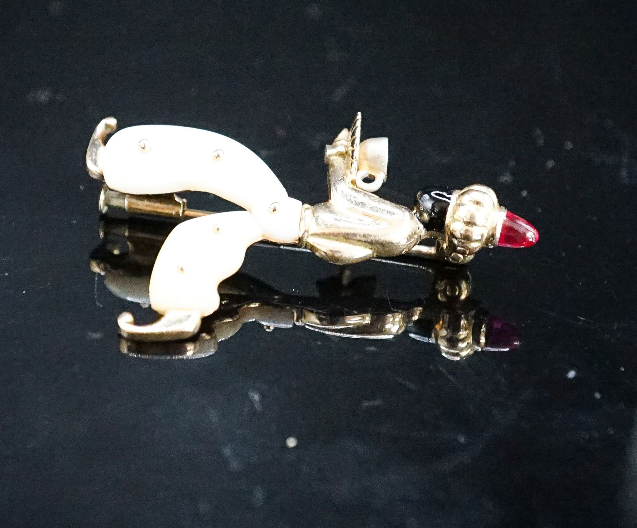 A 20th century Viennese 585 yellow metal, black enamel, mother of pearl and cabochon set brooch, modelled as a Blackamoor, 41mm, gross weight 7.2 grams.
